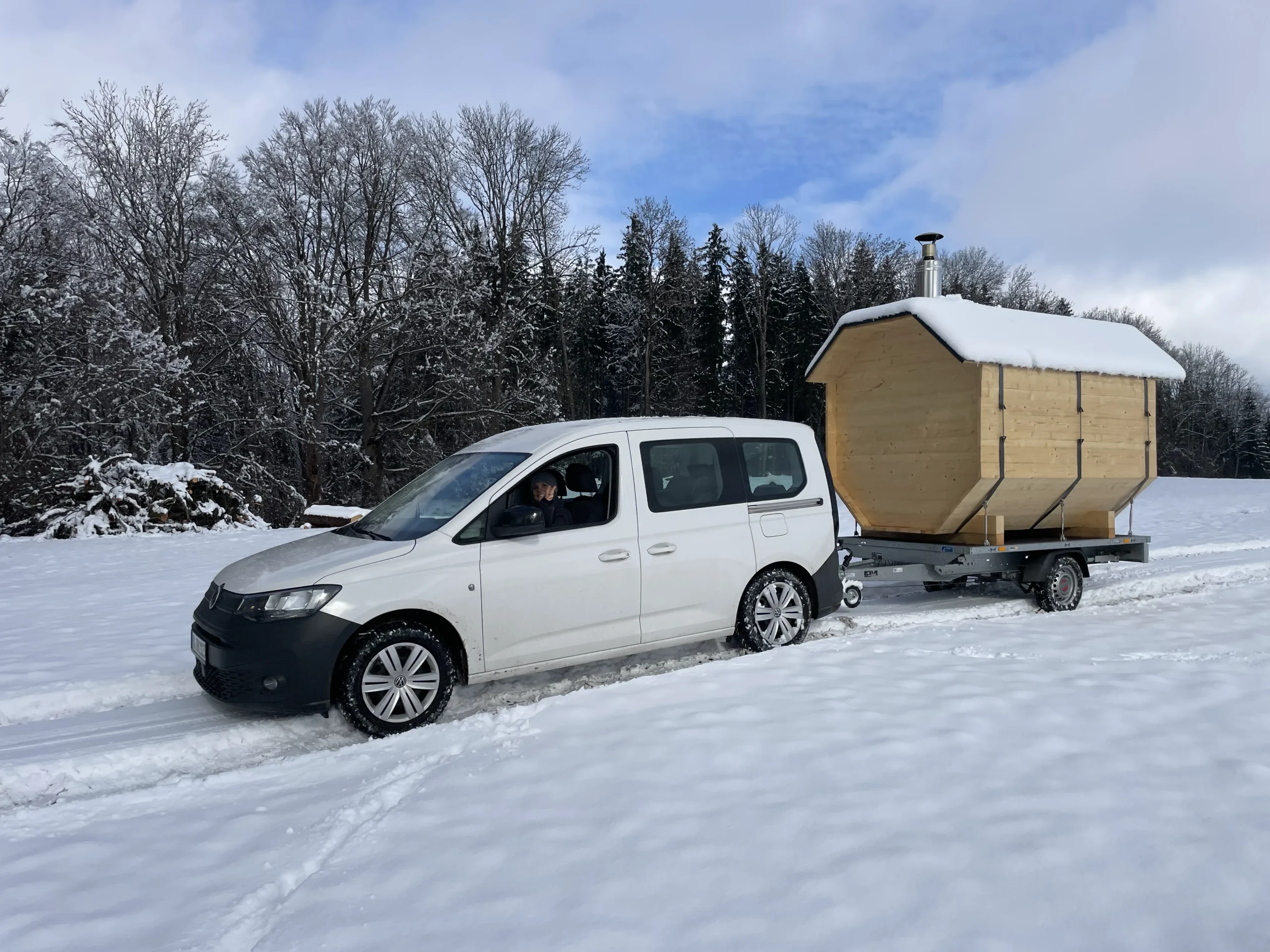 Sauna auf Anhänger angehängt am Auto im Schnee