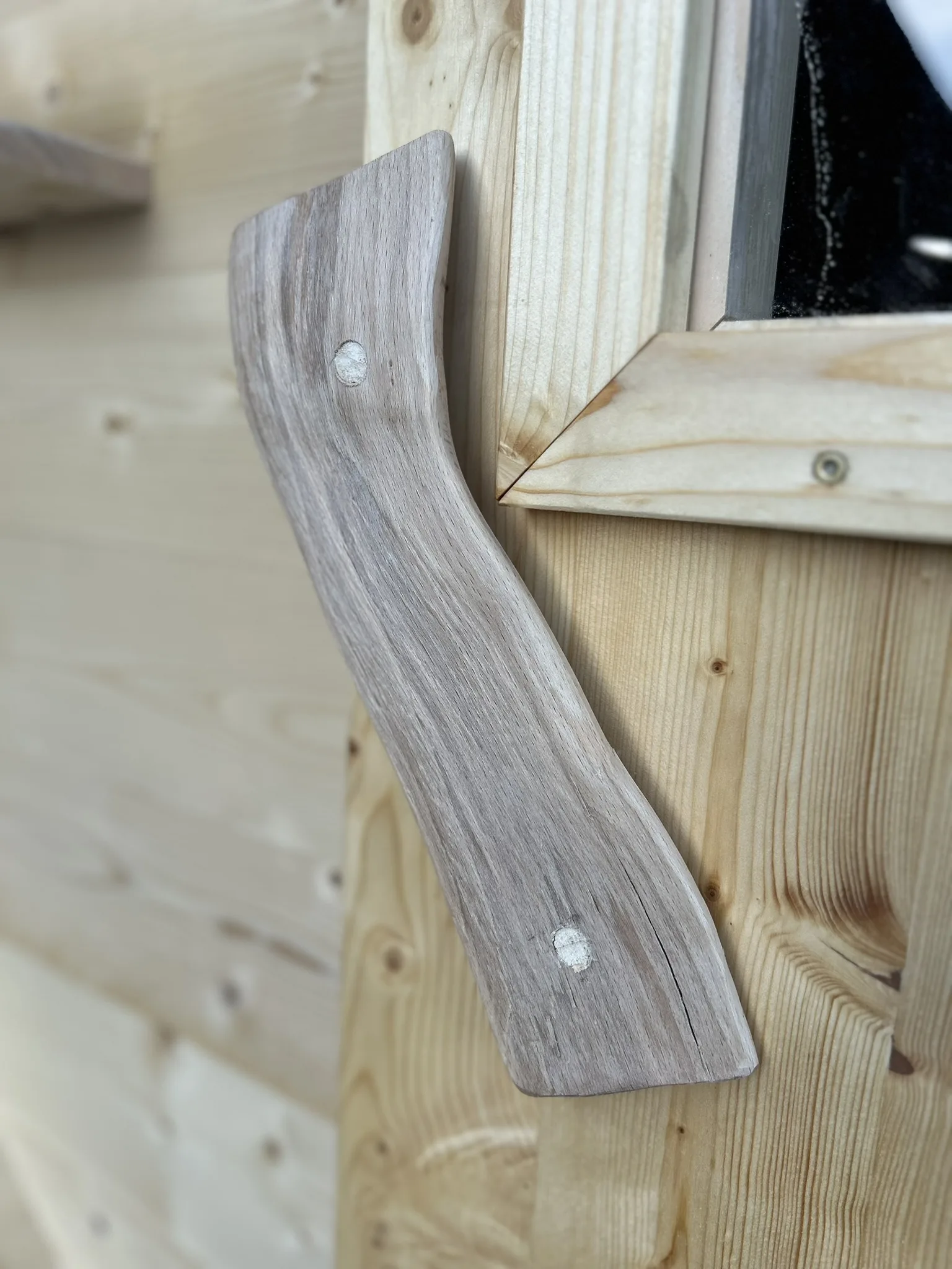 Geschwungener Türgriff aus Holz der mobilen Sauna